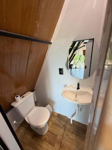 a small bathroom with a toilet and a sink at Chalé refugio de Igaratá in Igaratá