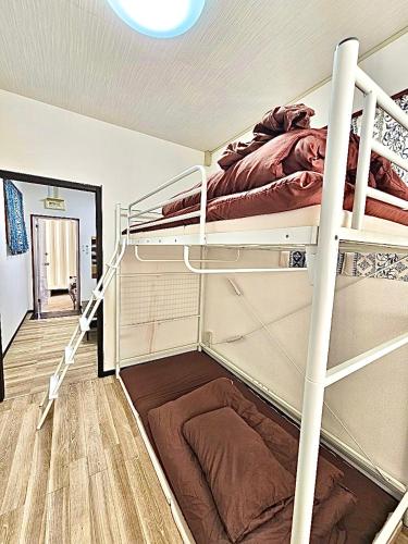 a room with two bunk beds and a hallway at 球美の駅 in Kumejima