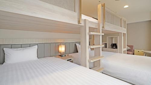 a bedroom with two bunk beds and a staircase at QuintessaHotel KagoshimaTenmonkan Relax&Sleep in Kagoshima