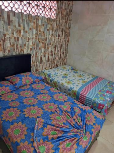 a bedroom with a bed with a colorful comforter at Hotel El Escorpión in Melgar