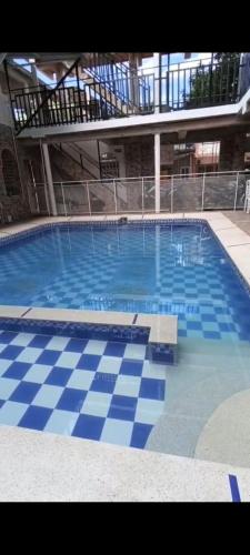 a large swimming pool with a blue and white tile floor at Hotel El Escorpión in Melgar
