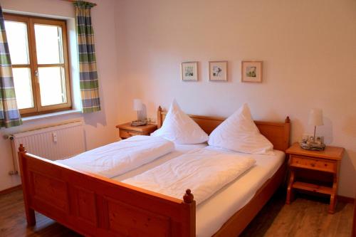 um quarto com uma cama com lençóis brancos e uma janela em Ferienwohnung Kühny Reute em Reute