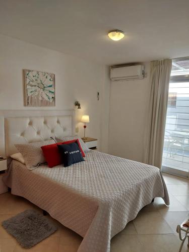 a bedroom with a bed with red pillows on it at Mirasol in Villa Carlos Paz