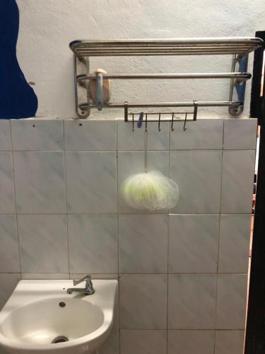 a bathroom with a sink and a toilet and a towel rack at Surf house langkawi in Pulau Tepur