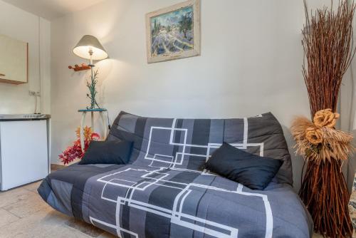 a bed with a blue and white comforter in a room at L'atelier de Raymond in Verfeuil
