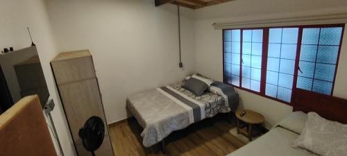a small bedroom with a bed and a window at Hostal LA MIA in Armenia