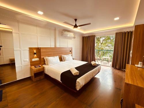 a bedroom with a large bed and a large window at Bellavista Resort Munnar in Munnar