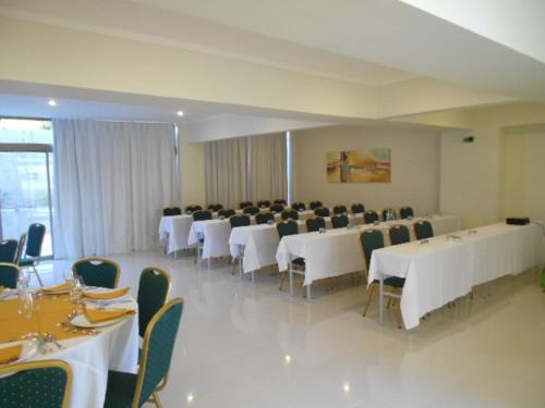 a banquet hall with white tables and chairs at Hotel Del Rio in Constitución