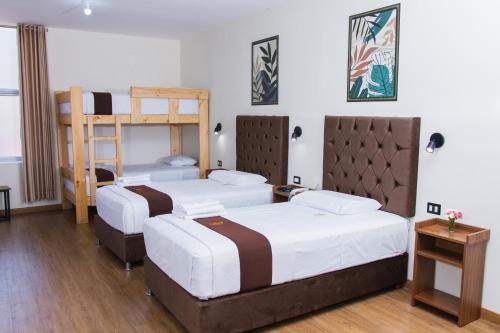 a room with three beds and a bunk bed at Zentra Plaza Hotel & Cowork in Chiclayo