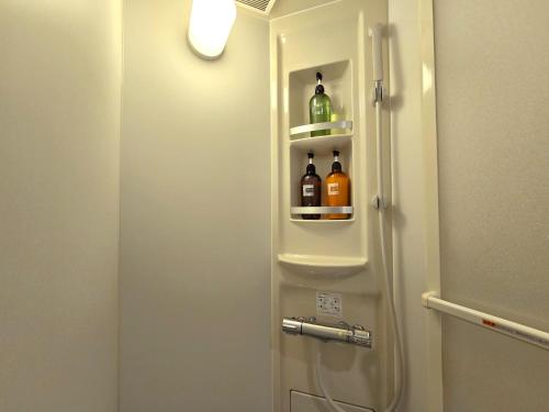 a bathroom with a door with bottles in it at Sea Style Resort OCEAN in Karatsu