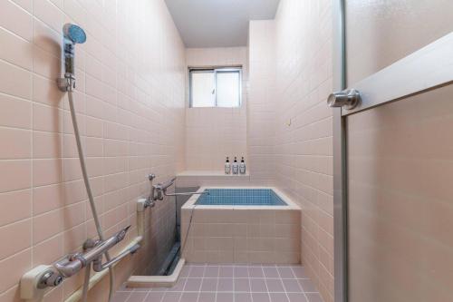 a small bathroom with a tub and a shower at Daini Kuwamura Building 4th in Tokyo