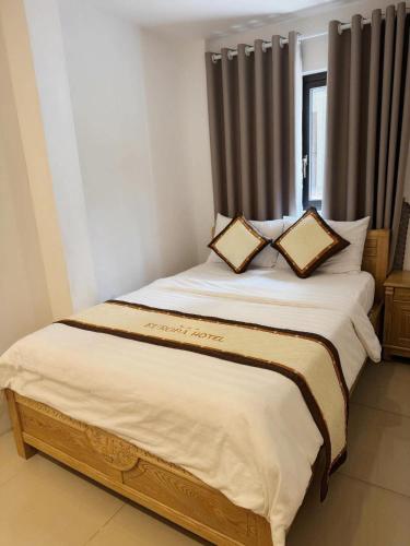 a bedroom with a large bed with two pillows at Europa Hotel in Da Lat