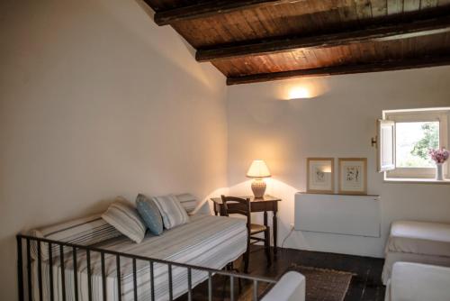 a bedroom with a bed and a table and a window at Masseria Degli Ulivi - Noto in Noto