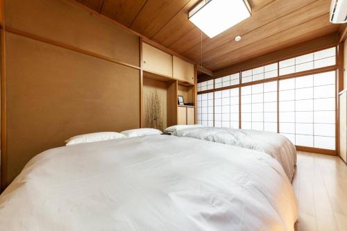 a bedroom with two beds in it with a window at Daini Kuwamura Building 4th in Tokyo