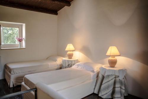 two beds in a room with two lamps on them at Masseria Degli Ulivi - Noto in Noto