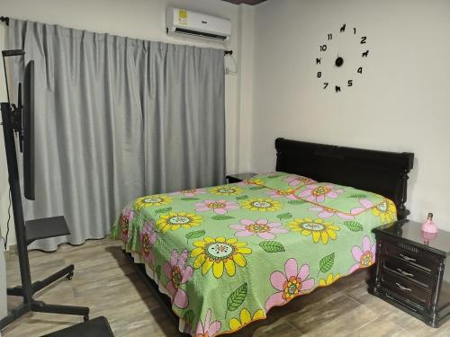 a bedroom with a bed and a clock on the wall at Maxi&Mia Cabañas in Coveñitas
