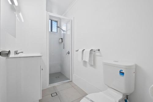 a white bathroom with a toilet and a shower at Ingenia Holidays Hervey Bay in Hervey Bay