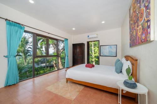 a bedroom with a bed and a large window at Nature's Hill side Phana House in Phuket