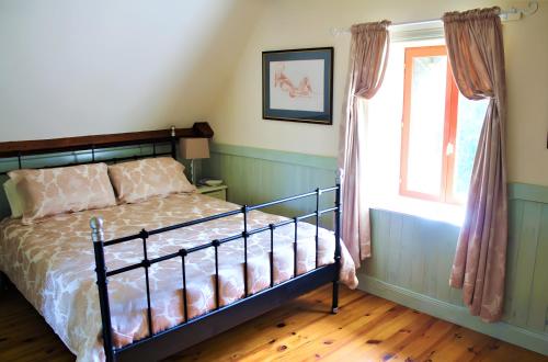 a bedroom with a bed and a window at River Cottage - La Mare Chappey in Néhou
