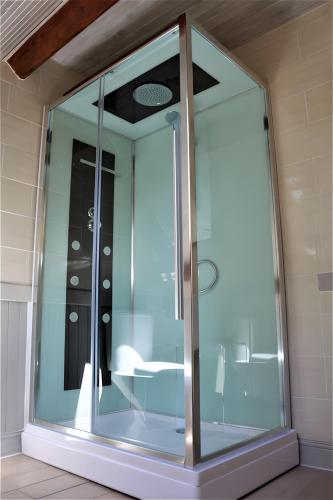a glass shower in a bathroom with a ceiling at River Cottage - La Mare Chappey in Néhou