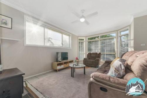a living room with a couch and a tv at 3B house Central Coast parking in Blue Haven