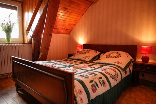 a bedroom with a bed with a comforter and pillows at Gîte le marlet in Saint-Alban-sur-Limagnole