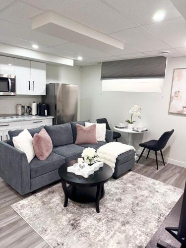 a living room with a couch and a table at Velvet and Rose Elegant Private 2BR Basement Suite in Winnipeg