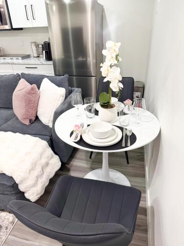 a table with plates and glasses on it in a living room at Velvet and Rose Elegant Private 2BR Basement Suite in Winnipeg