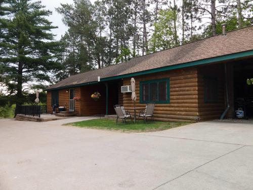 a log cabin with a table and chairs in front of it at 2BR 1BA Cabin #2 Riverside Point Resort in Park Rapids