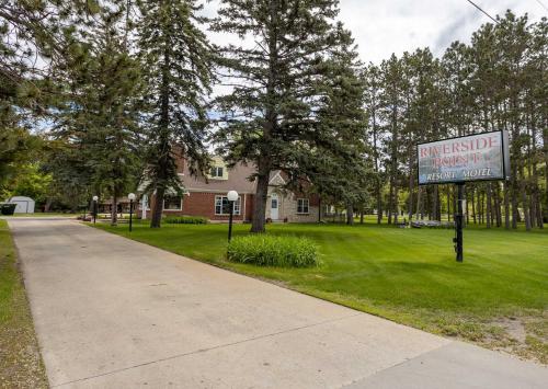 a sign in the grass in front of a house at 2BR 1BA Cabin #2 Riverside Point Resort in Park Rapids