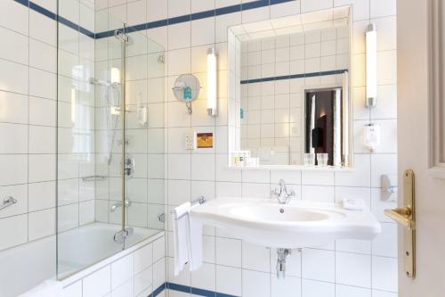 a bathroom with a sink and a shower at Mercure Grand Hotel Biedermeier Wien in Vienna