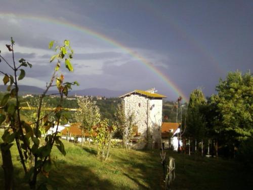 a rainbow in the sky over a field with a house at Torre del Drago in Borgo alla Collina