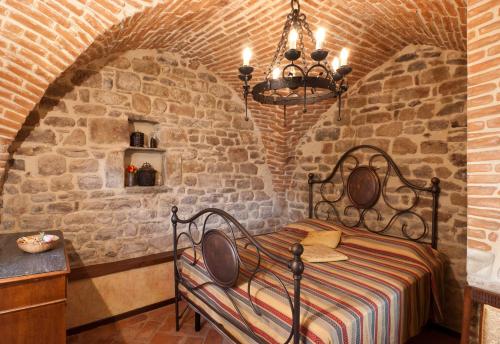 a bedroom with a bed in a brick wall at Torre del Drago in Borgo alla Collina