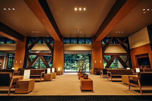 a large lobby with chairs and tables and windows at Ooedo Onsen Monogatari Premium Shirahama Gyoen in Shirahama