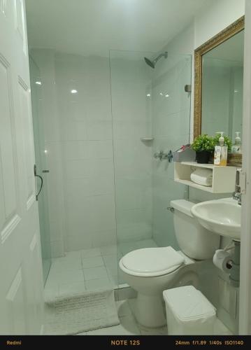 a white bathroom with a toilet and a sink at Hotel Fegali Art Boutique in Cartagena de Indias