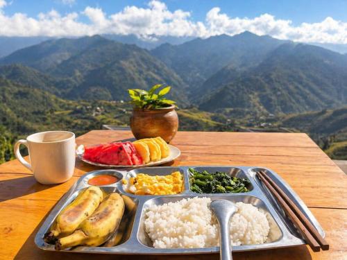 a tray of breakfast food on a table with mountains at Indigenous homestay - Trek & Local Life in Mù Cang Chải