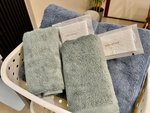 three towels sitting in a laundry basket at GoodStay505 in Kurume