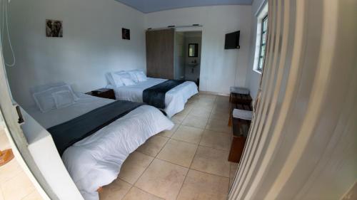 a hotel room with two beds and a television at Refugio en la naturaleza in La Vega