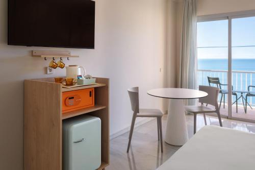 a hotel room with a bed and a table with chairs at SOL by Meliá Málaga Guadalmar in Málaga