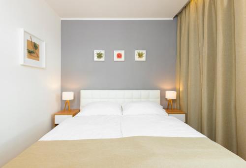 a bedroom with a large white bed with two lamps at Hotel Garden Court in Prague