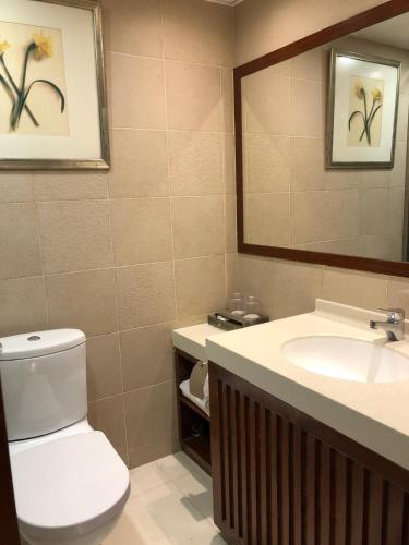 a bathroom with a toilet and a sink and a mirror at Warwick Hotel Cheung Chau in Hong Kong