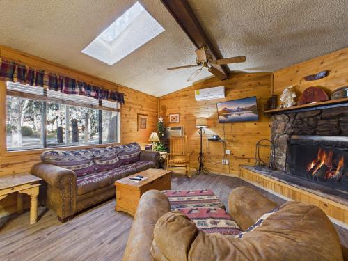 a living room with a couch and a fireplace at Whispering Pine Cabins in Ruidoso