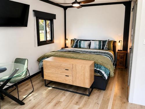 a bedroom with a bed and a table and a tv at Mansfield Holiday Park in Mansfield