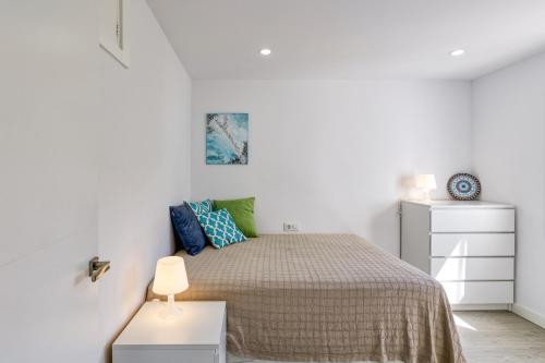 a white bedroom with a bed and a white dresser at Apto Nidos cerca de la playa in L'Escala