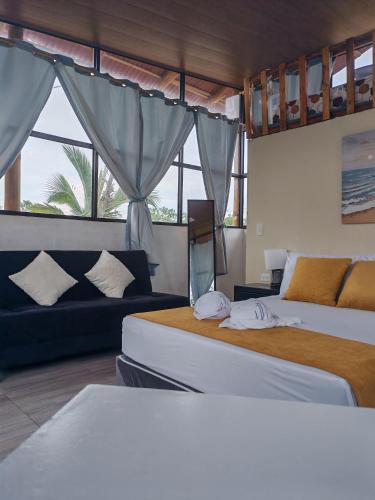 a bedroom with two beds and a couch and a window at Glampings Boreal in Mompiche
