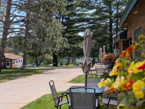 a group of tables and chairs with an umbrella at 2BR 1BA Cabin #3 Riverside Point Resort in Park Rapids