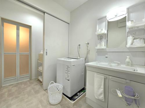 a white bathroom with a sink and a mirror at 鶴城丸（KAKUJYOMARU） in Karatsu