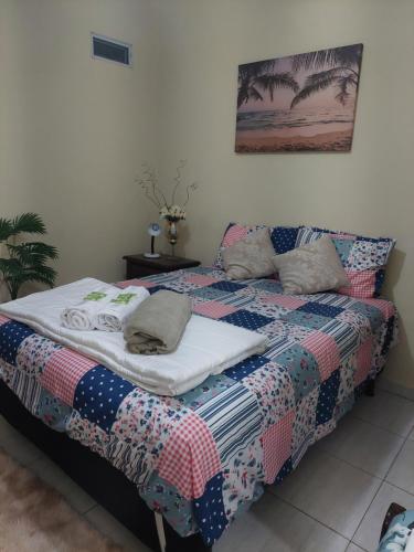 a bed with a quilt on it in a bedroom at Pousada Summer Beach by Itaúna in Saquarema