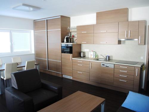 a kitchen with wooden cabinets and a chair and a table at Apartmány na Dolní Moravě in Dolní Morava