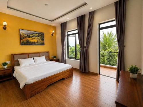 a bedroom with a bed and a large window at An Velora Boutique Hotel in Lai Nghê (2)